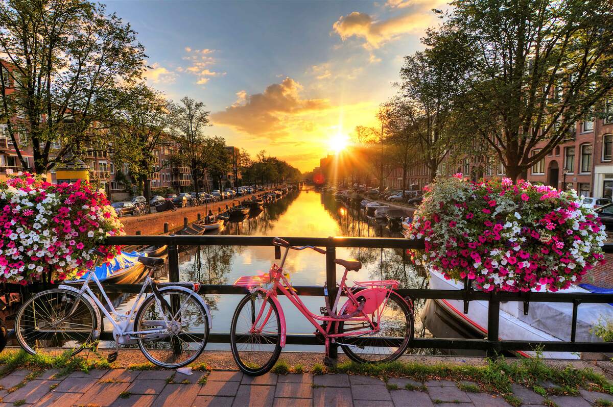 Fototapeta zachód słońca w amsterdamie z rowerami w tle