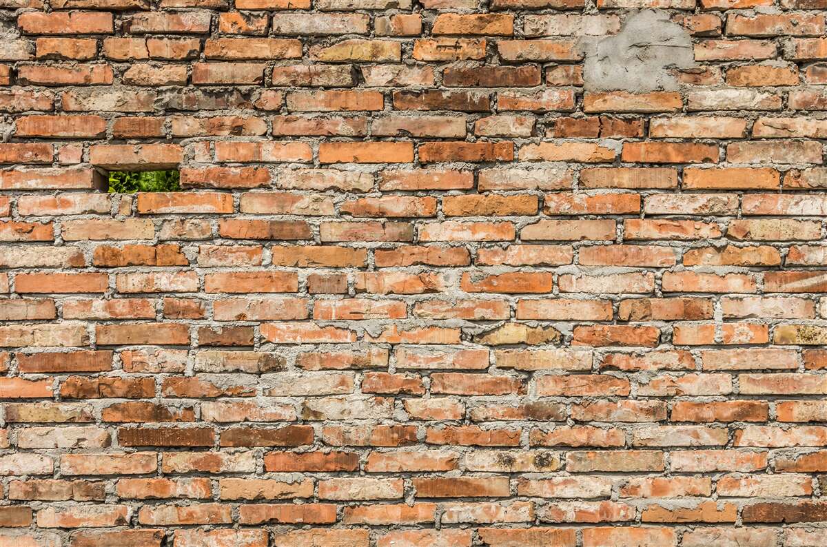 Fototapeta Ściana, z której spadają cegły, które straciły świeżość